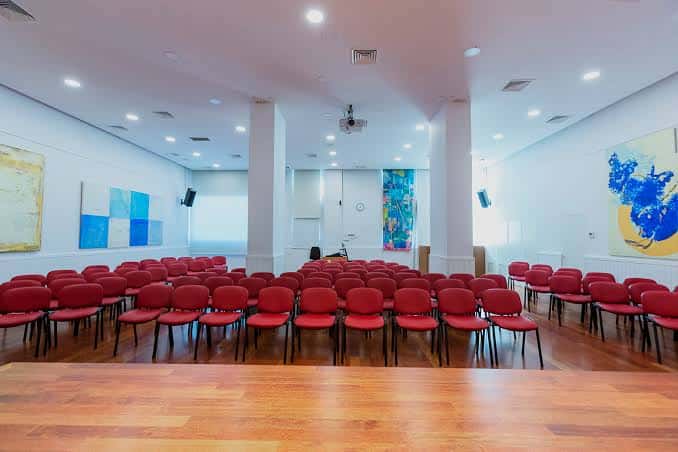 Aula o sala de conferencias con butacas rojas
