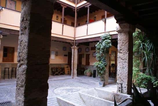 Patio central de la Corrala de Santiago con columnas de piedra y fuente en el centro