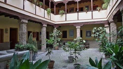Patio ajardinado de la Corrala de Santiago con plantas y arquitectura tradicional andaluza