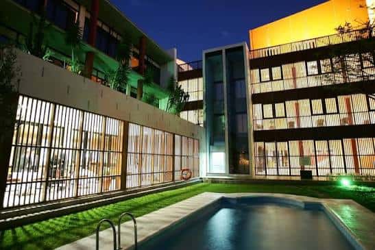 Fachada iluminada del hotel Escuela Santa Cruz por la noche