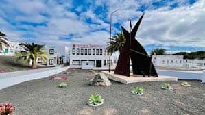 Vista exterior de la Casa de la Juventud con escultura moderna en el patio
