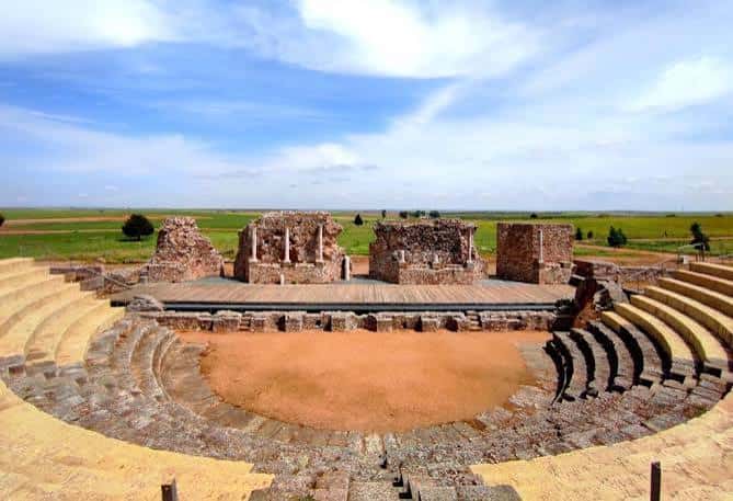 Vista panorámica del Teatro Romano de Regina Turdulorum con escenario y gradas bajo cielo azul