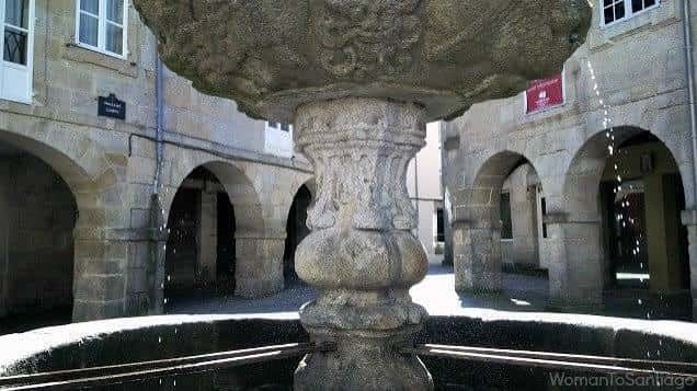 Detalle de la fuente de piedra en el centro de la plaza