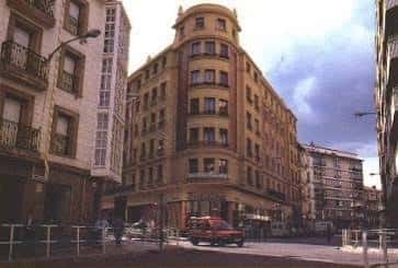 Esquina histórica de la Calle Fueros con edificio curvo y tráfico urbano