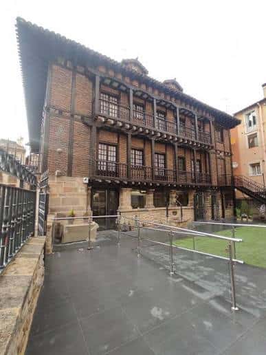 Vista exterior del Palacio de la Burullería mostrando su fachada tradicional con balcones de madera y detalles arquitectónicos