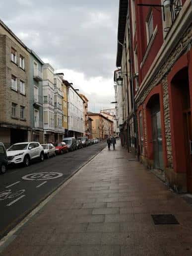 Vista actual de la Calle Nueva Fuera en Vitoria con edificios residenciales y vehículos estacionados
