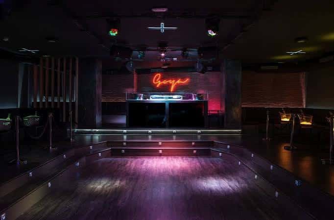 Vista del interior del club con pista de baile y barra iluminada