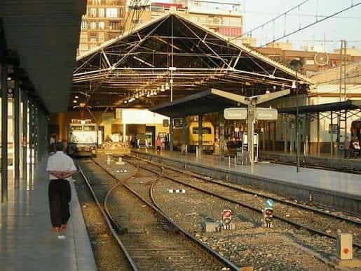 Plataformas de la estación con trenes y estructura metálica bajo techo