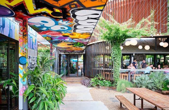 Pasillo decorado con arte callejero colorido y plantas