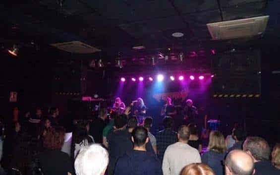 Concierto en vivo con banda tocando bajo luces de escenario