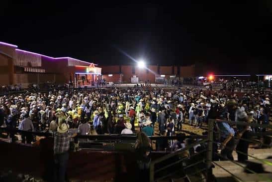 Plaza de toros R3 durante un evento nocturno con multitud en el ruedo e iluminación escénica