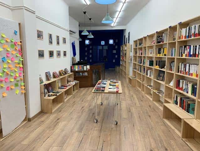Interior amplio de librería con estanterías de madera y suelo claro