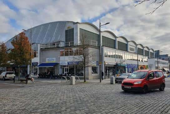 Vista exterior del Plymouth Pannier Market con su característica fachada curva y entrada principal