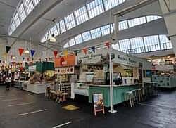Interior del mercado mostrando puestos de comida y decoración festiva bajo techo