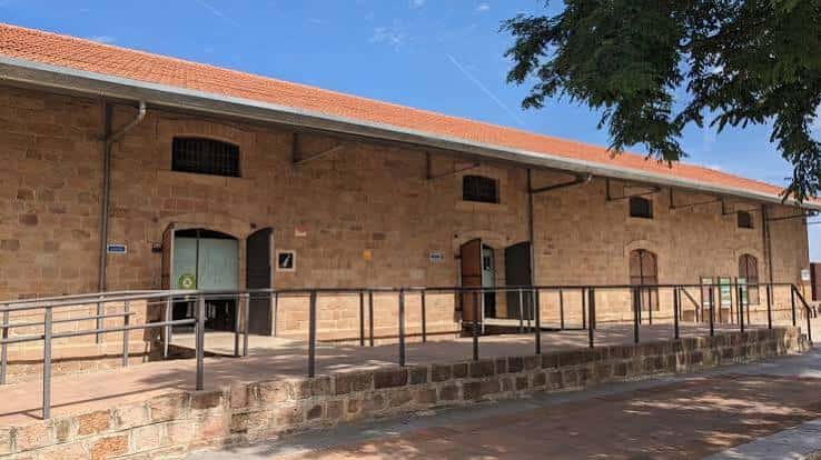 Fachada exterior del edificio histórico con rampa de acceso y tejado de tejas