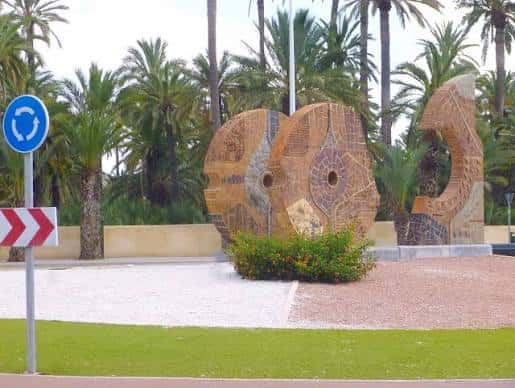 Detalle de las esculturas y palmeras en la rotonda de Elche