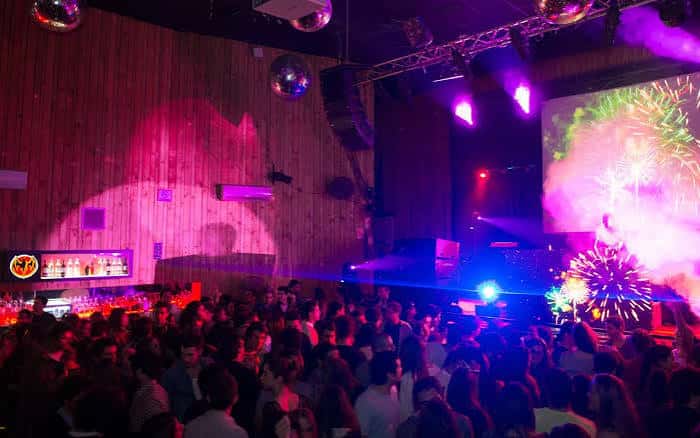 Interior del Macarena Club con multitud de personas y luces de neón