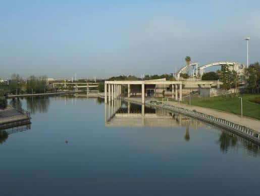 Reflejo en el agua de estructuras contemporáneas y puentes del parque