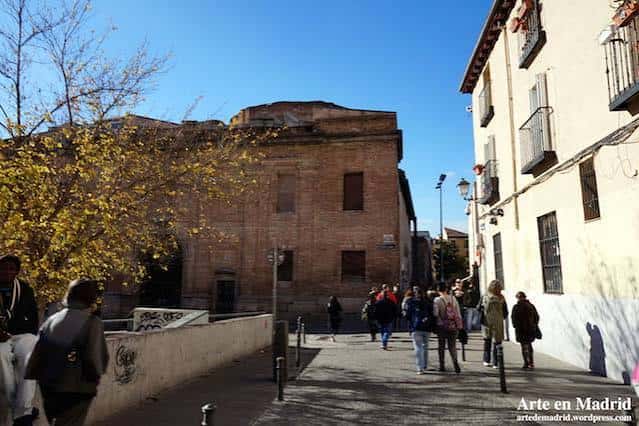 Vista peatonal de la plaza con personas caminando y arquitectura tradicional madrileña