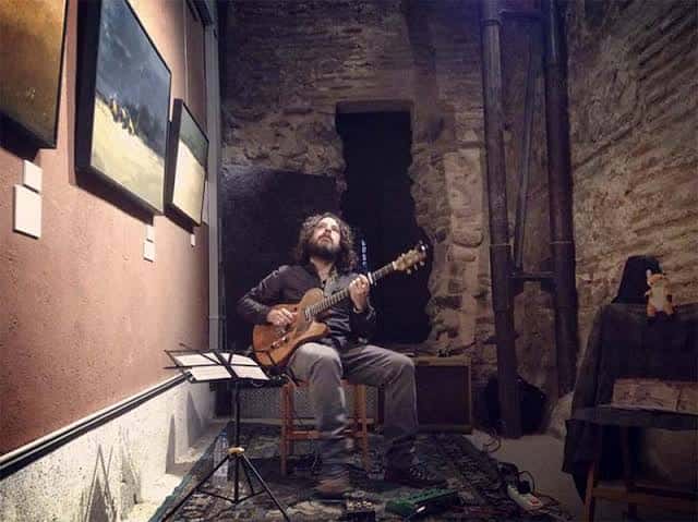 Músico tocando guitarra en el interior de la Cámara Bufa durante un evento cultural