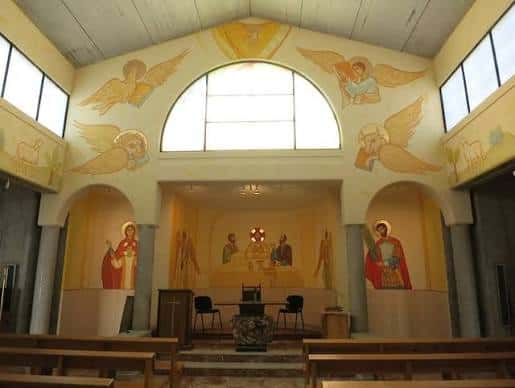 Interior de la Capilla de la Adoración Eucarística con murales de ángeles y santos