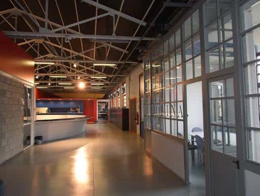 Pasillo interior del espacio con estructura metálica y paredes de cristal