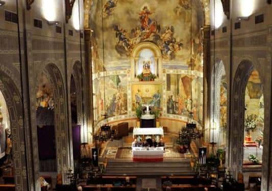 Interior del altar mayor con pinturas murales y decoración religiosa