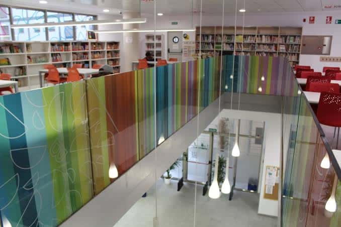 Vista interior de la biblioteca con estanterías y zona de lectura
