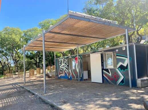 Vista exterior del Aula Ambiental de Sants-Montjuïc con estructura metálica y techo de madera en un entorno natural