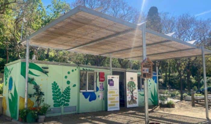 Fachada del edificio del Aula Ambiental decorada con murales ecológicos y rodeada de vegetación