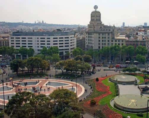 Área central de la plaza con jardines floridos y arquitectura emblemática