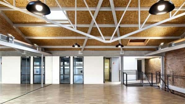 Interior del salón de eventos con suelo de madera y techo industrial