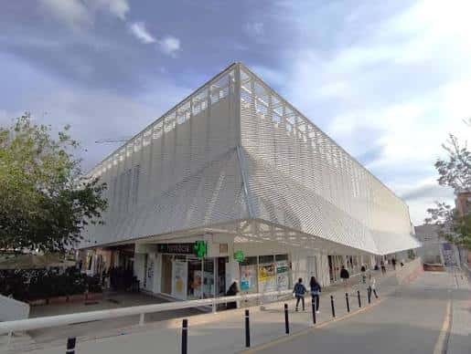Fachada principal del mercado renovado con entrada accesible y peatones