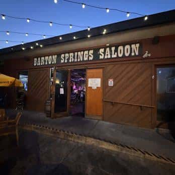 Fachada exterior del Barton Springs Saloon con iluminación de luces colgantes