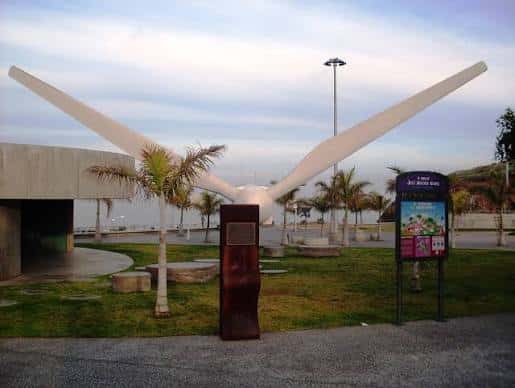 Escultura de alas blancas en el Parque José Segura Clavell con palmeras y zona ajardinada