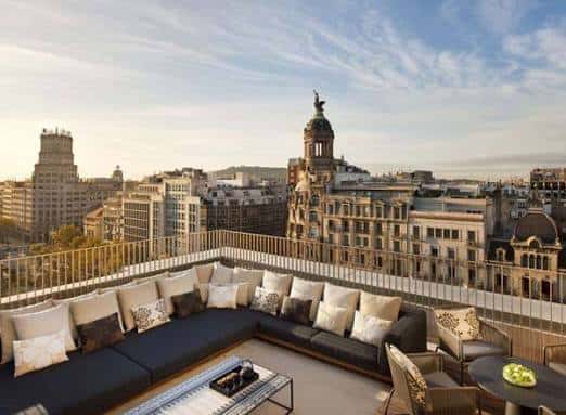 Terraza con sofás y vistas panorámicas de Barcelona al atardecer