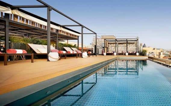 Piscina en la azotea del hotel con tumbonas y pérgolas