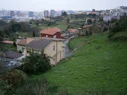Vista elevada desde el monte mostrando edificios residenciales y el paisaje urbano de A Coruña al fondo