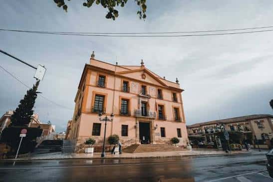 Fachada del Palacio de los Condes de Villa Paterna en día nublado con reflejos en el suelo
