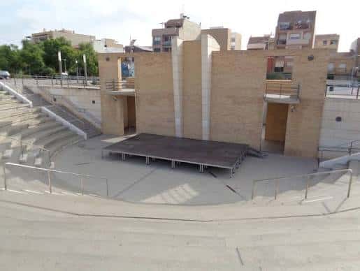 Vista general del anfiteatro al aire libre con escenario y gradas de piedra