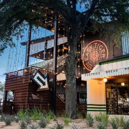 Fachada exterior de Easy Tiger South Lamar con iluminación cálida y decoración festiva