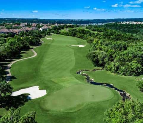 Vista aérea del campo de golf con greens bien cuidados y bunkers blancos