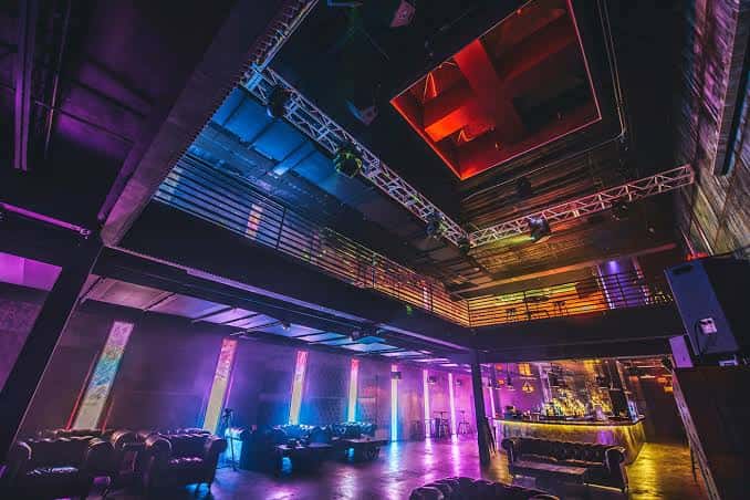 Interior del Vulcan Gas Company con iluminación de neón y zona de bar