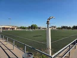Vista panorámica del campo de fútbol con césped artificial bajo un cielo despejado