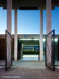 Entrada principal al recinto deportivo con columnas y portones abiertos al atardecer