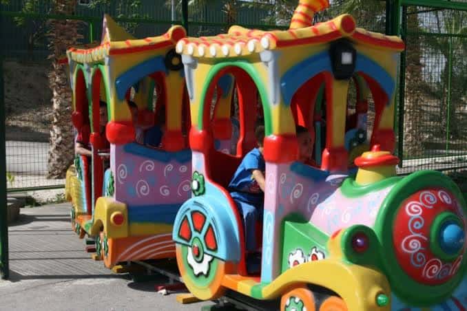 Tren infantil colorido en movimiento dentro del parque