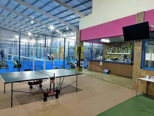 Área de descanso con mesa de ping pong y barra del club deportivo