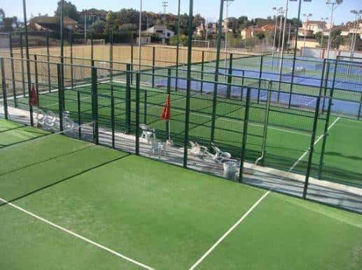 Pistas exteriores de tenis y pádel con césped artificial bajo luz diurna
