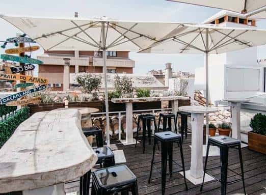 Terraza exterior de Lemon Rock con mesas y vistas urbanas
