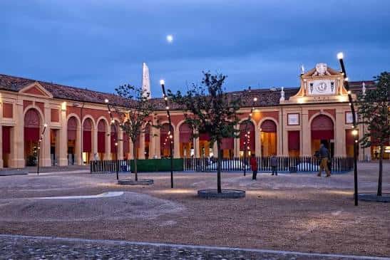 Fachada iluminada del Pavaglione al atardecer con luna visible